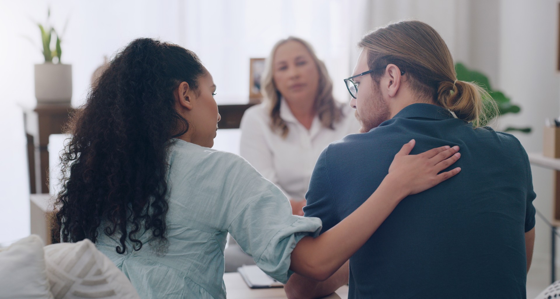 Marriage, counselling and couple in therapist office giving comfort, care and talking to partner. Man and black woman with social worker or psychologist for problem, support and help in relationship