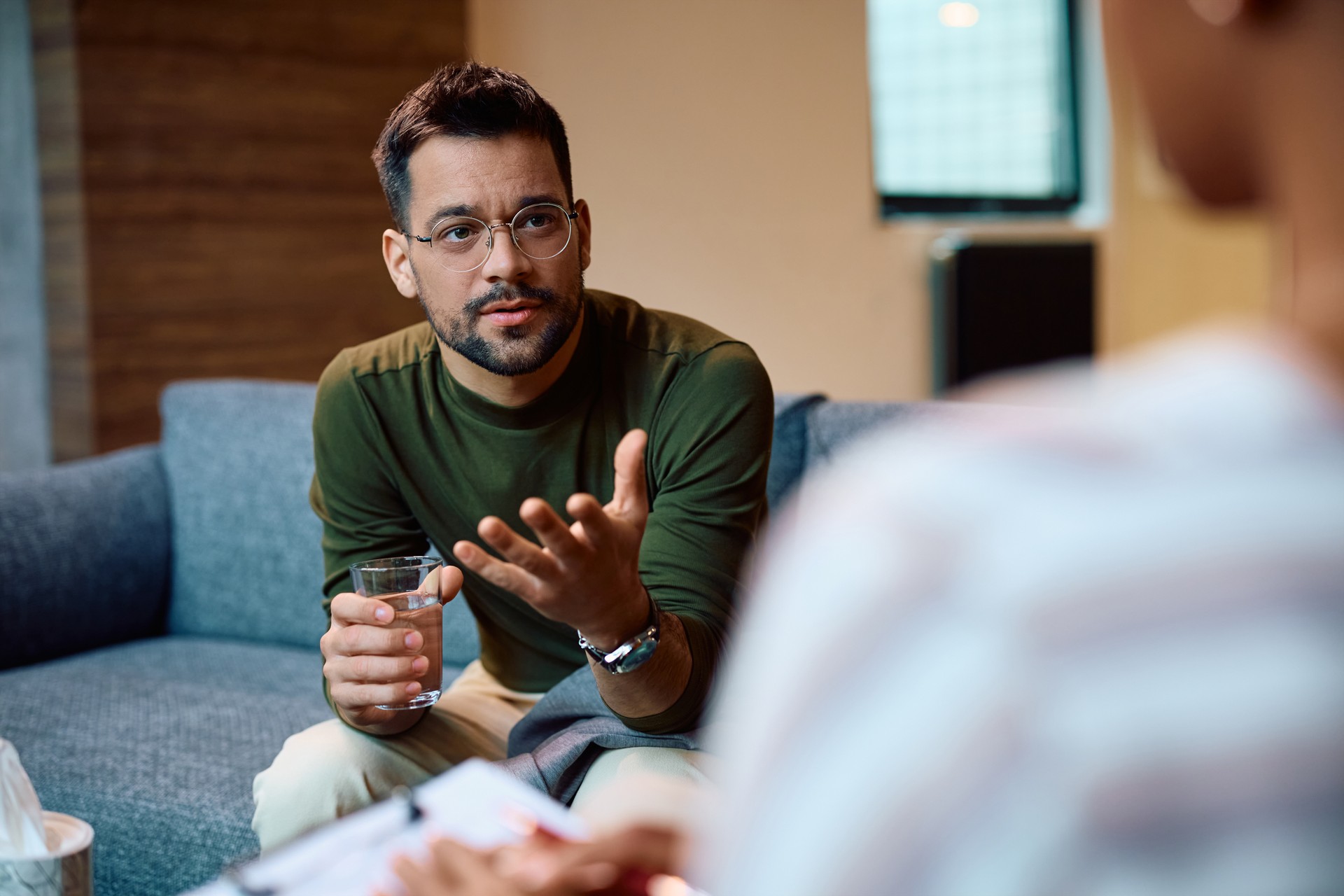 Young man having counseling with mental health professional in the office.